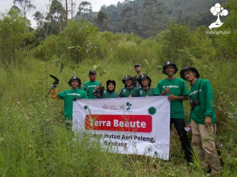 Mitra petani bibit LindungiHutan berfoto dengan Banner Terra Beaute usai kegiatan penanaman.