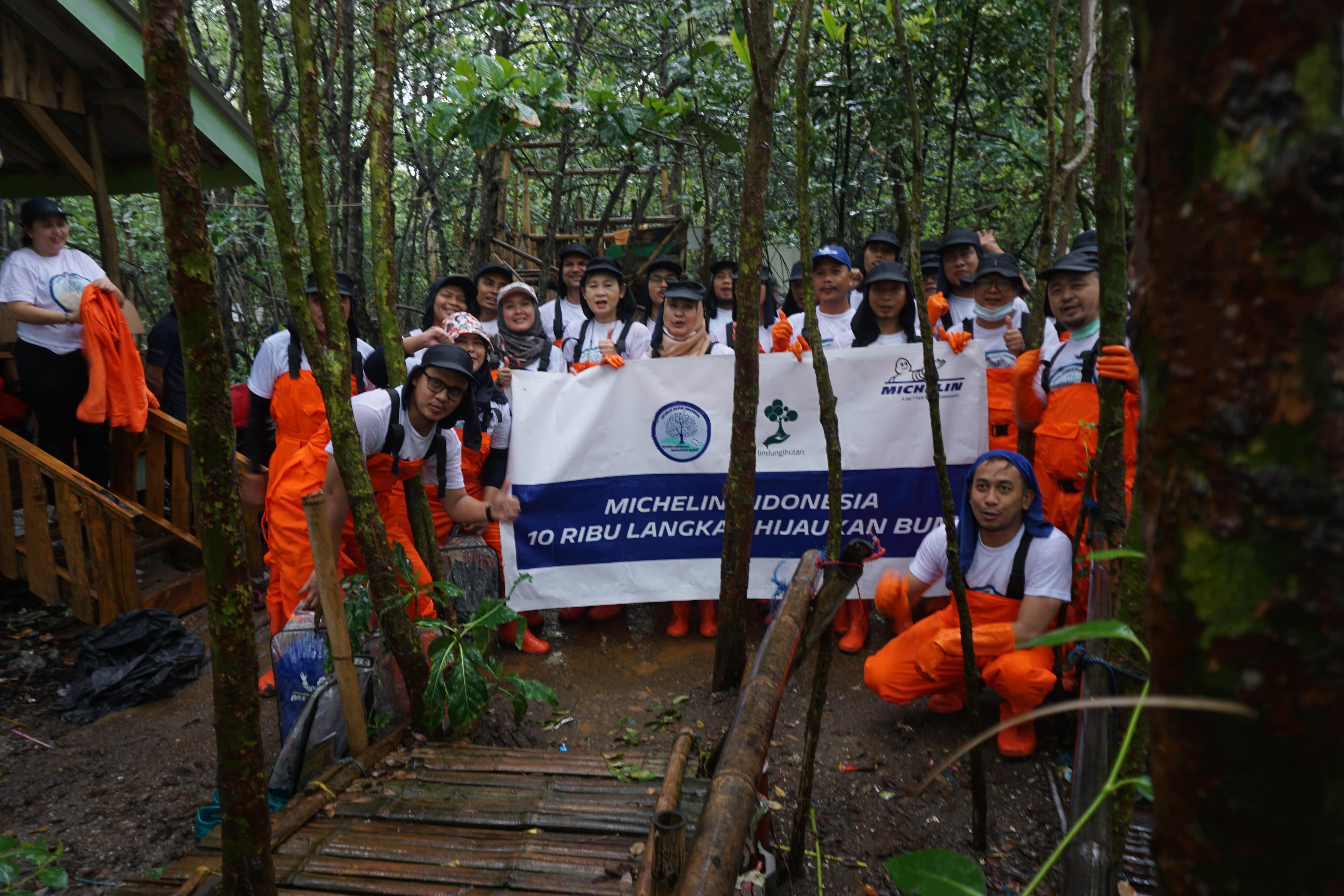 Karyawan PT Michelin Indonesia berfoto di lokasi penanaman pohon mangrove.